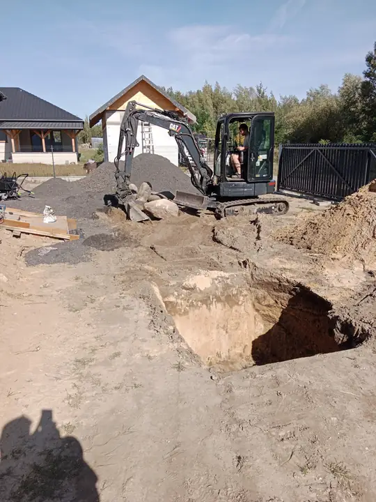 Głęboki wykop pod system odwodnienia w Jedlance, mini koparka w tle